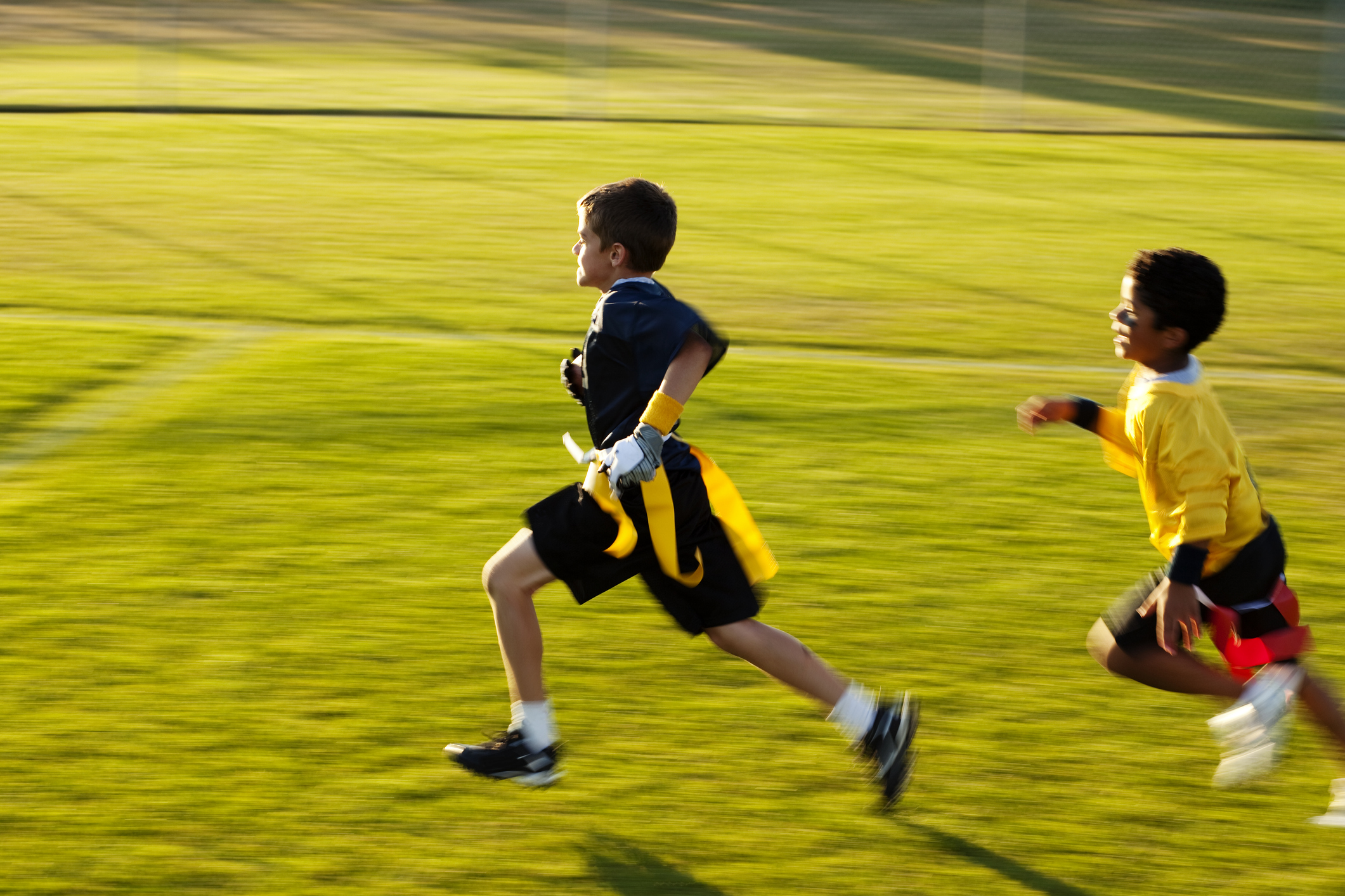 A young flag football player goes for the touchdown.