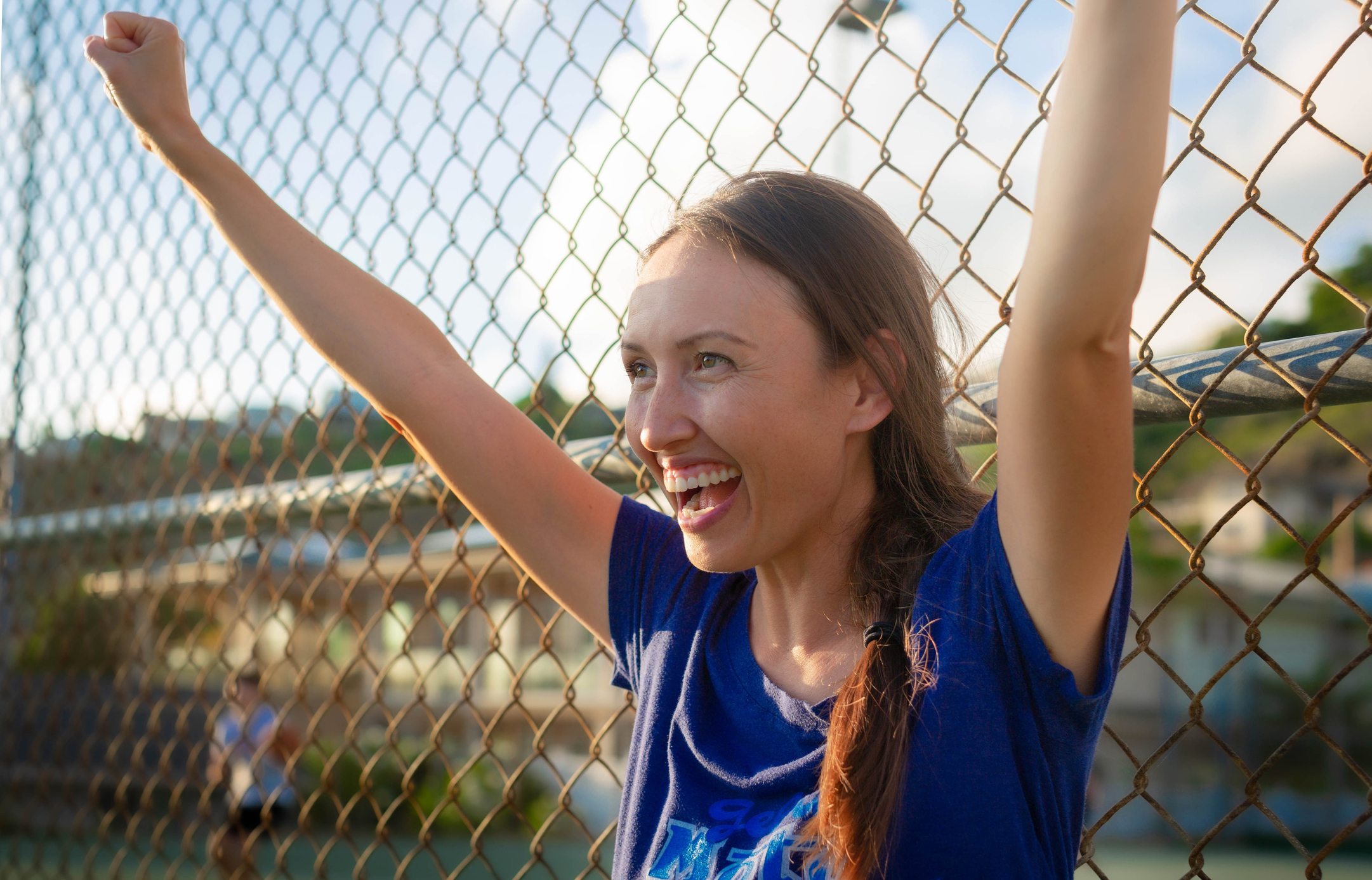 a excited proud mother cheering on her kid at a game outside.